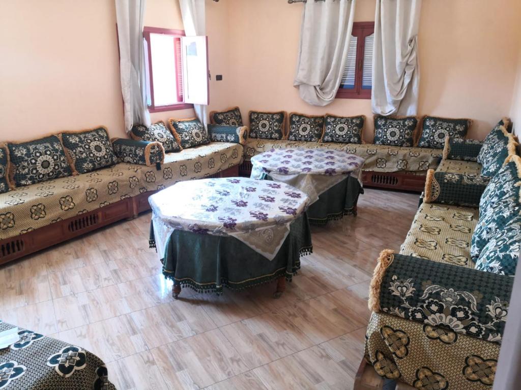 een woonkamer met banken en tafels bij Family house 2 bedrooms, 2 sdb, near Center of Nador & Airport in Selouane