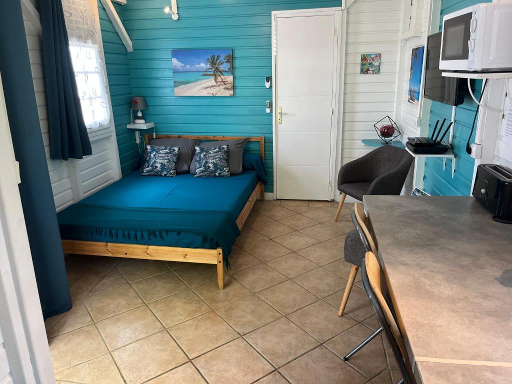a small room with a blue wall at Bungalow avec piscine in Sainte-Marie
