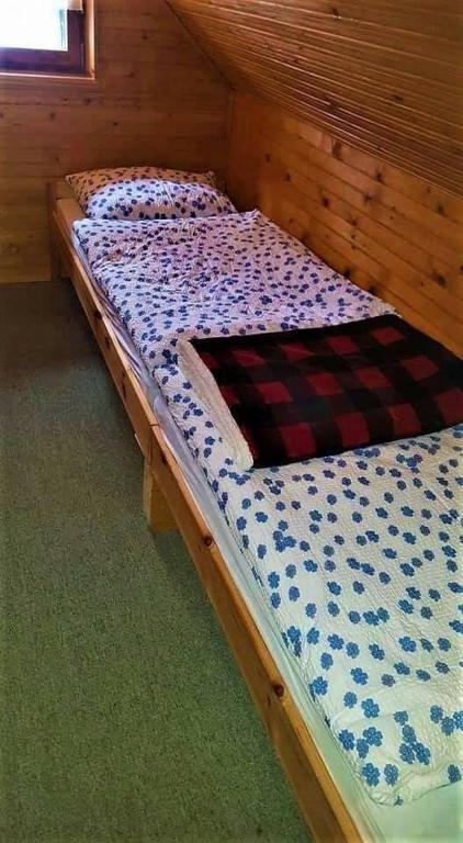 a bed in a wooden room with at Rogla - Chalet Mojca Pokrajculja in Zreče