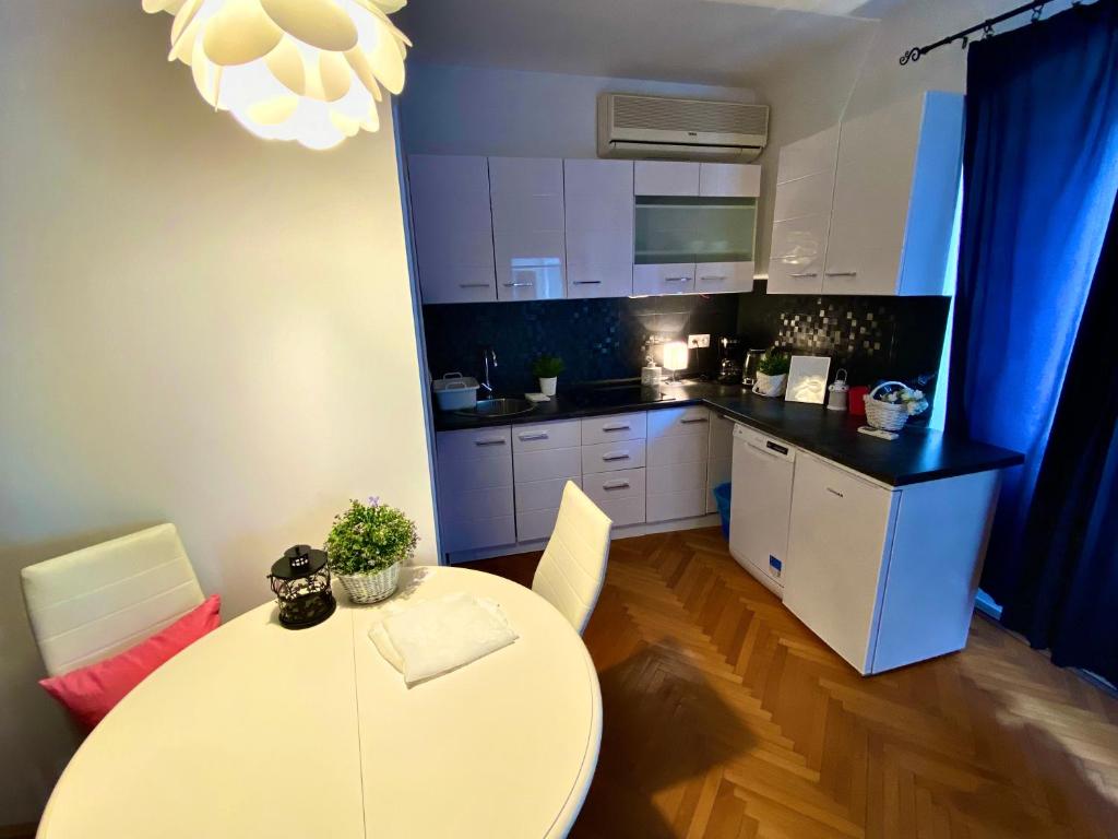 a kitchen with a white table and a dining room at City Square Apartment in Poreč