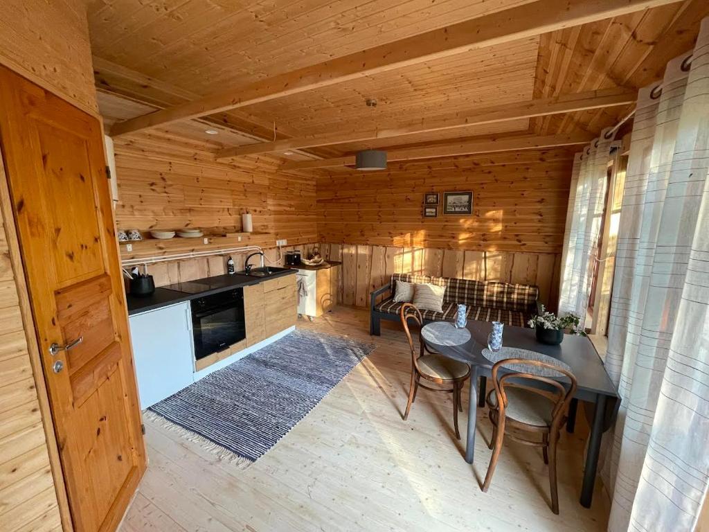 una cocina con mesa y sillas en una cabaña en JUST Lodges, en Orissaare