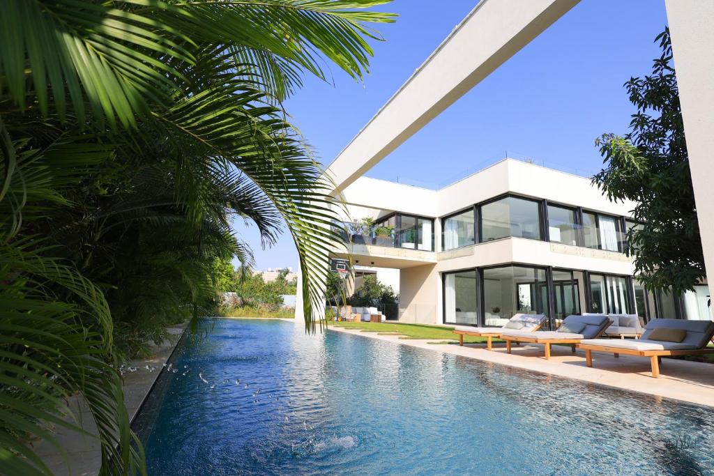 una casa con piscina di fronte a una casa di Breathtaking Villa w Pool & Sauna Near the Beach by Sea N' Rent a Herzelia
