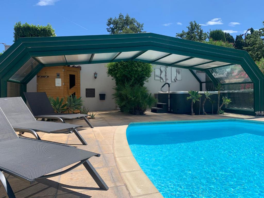 a pavilion over a swimming pool in a backyard at Residence Melody in Saint-Rémy-de-Provence