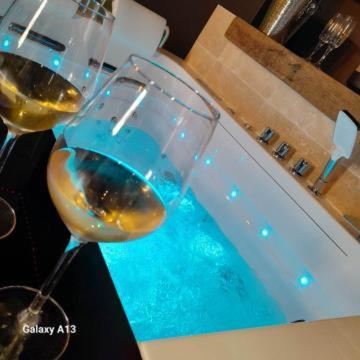 a couple of glasses of white wine next to a tub at instant à deux in Précigné