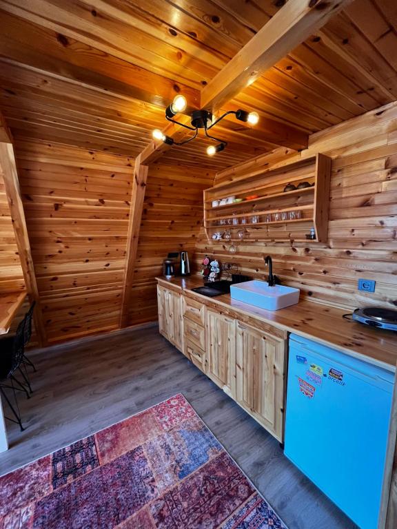 una cocina en una cabaña de madera con fregadero en Sapanca Havuzlu jakuzili süit Bungalov en Sapanca