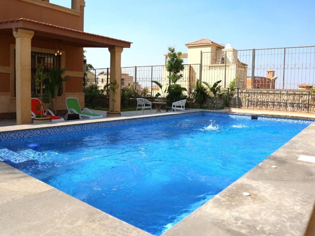 a large blue swimming pool in front of a house at Royal Mansion with private pool in sheikh zayed Compound families in Sheikh Zayed