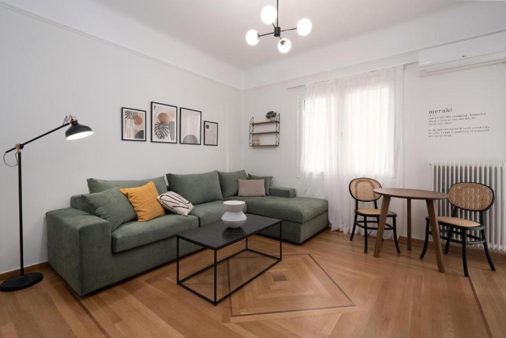 a living room with a green couch and a table at Vibrant Urban Getaway: Modern 1-Bedroom near Bars, Parks, and Metro in Athens