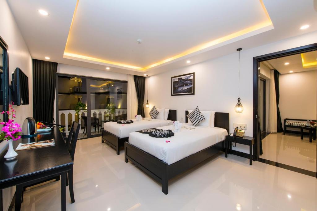Giường trong phòng chung tại Gem Riverside Hotel Hoi An