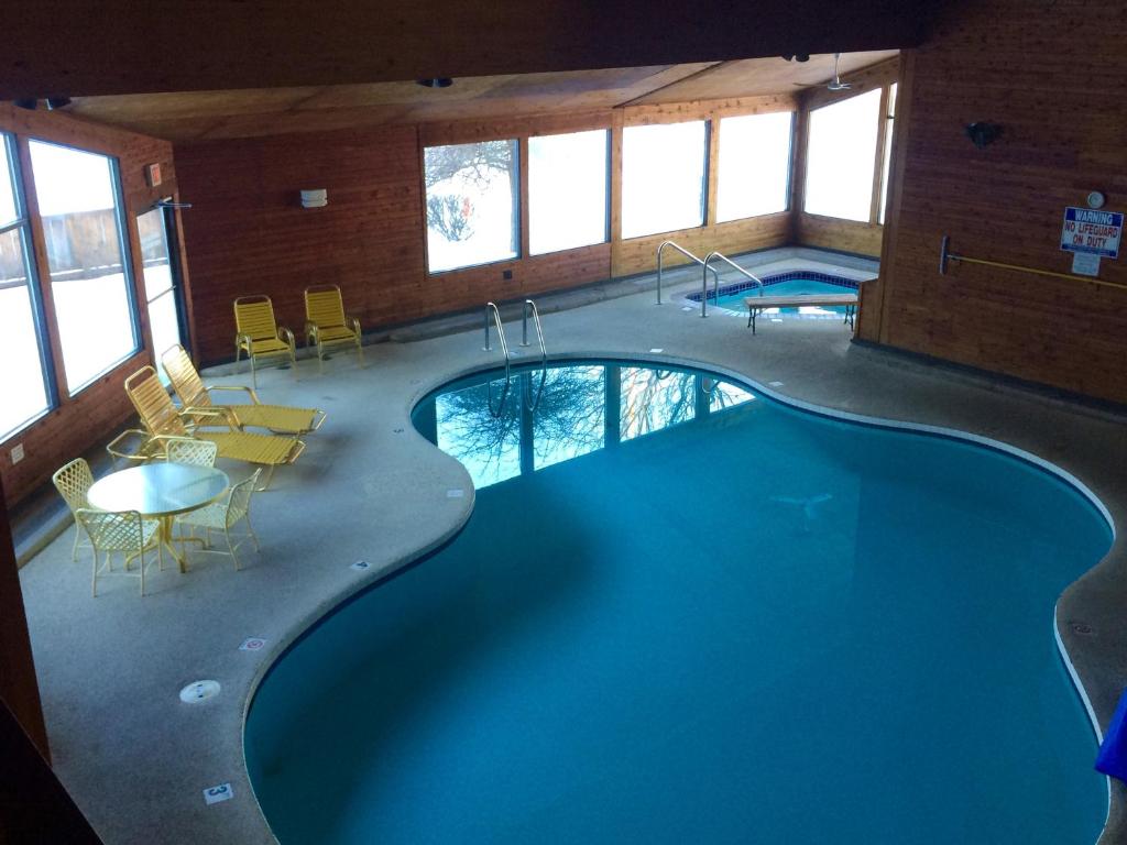 a large swimming pool in a building with a table and chairs at Cedar Motor Inn in Marquette