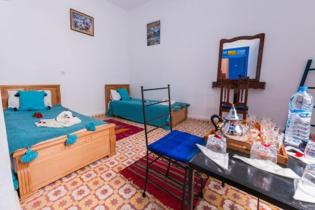 1 dormitorio con cama, espejo y mesa en Riad AYLAL en Esauira