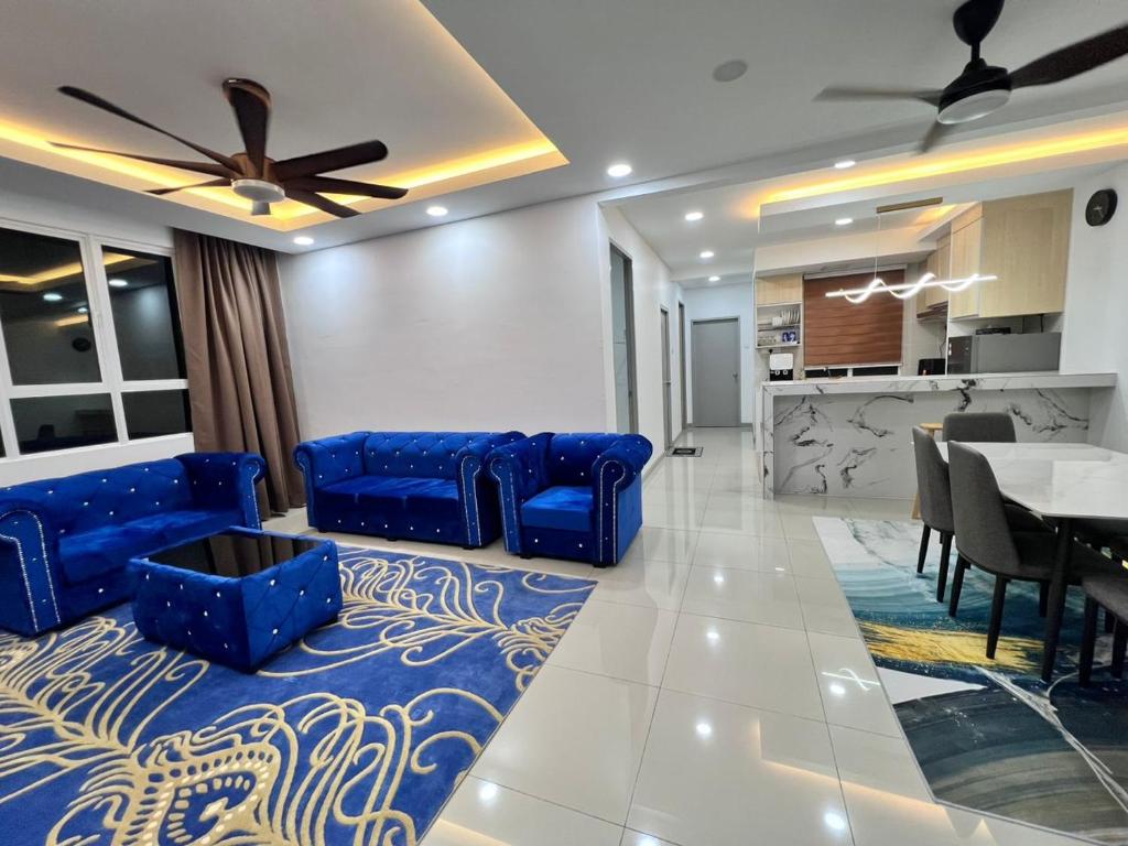 a living room with blue couches and a dining room at Qaisara Qais Homestay in Kuala Terengganu