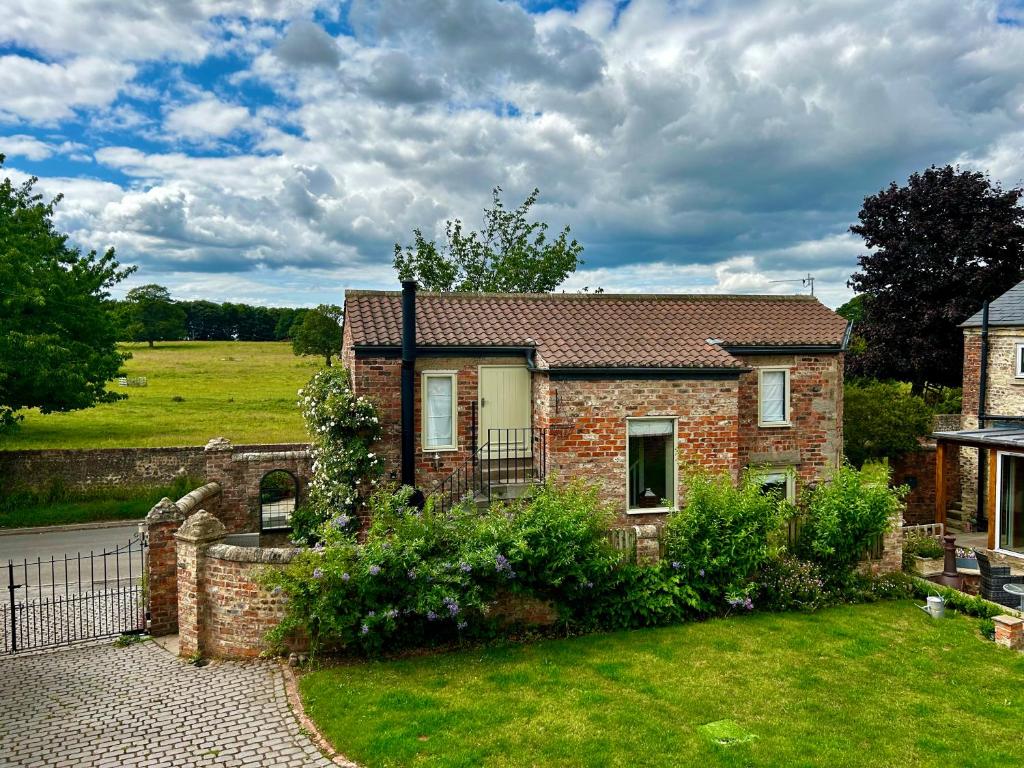 約克的住宿－Tanyard Cottage - Whixley, York, North Yorkshire，庭院里带花园的砖房