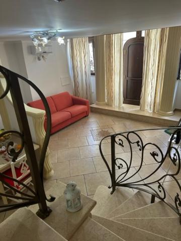 uma sala de estar com um sofá vermelho e uma escada em Casa vacanze Conte Cavour em Laterza