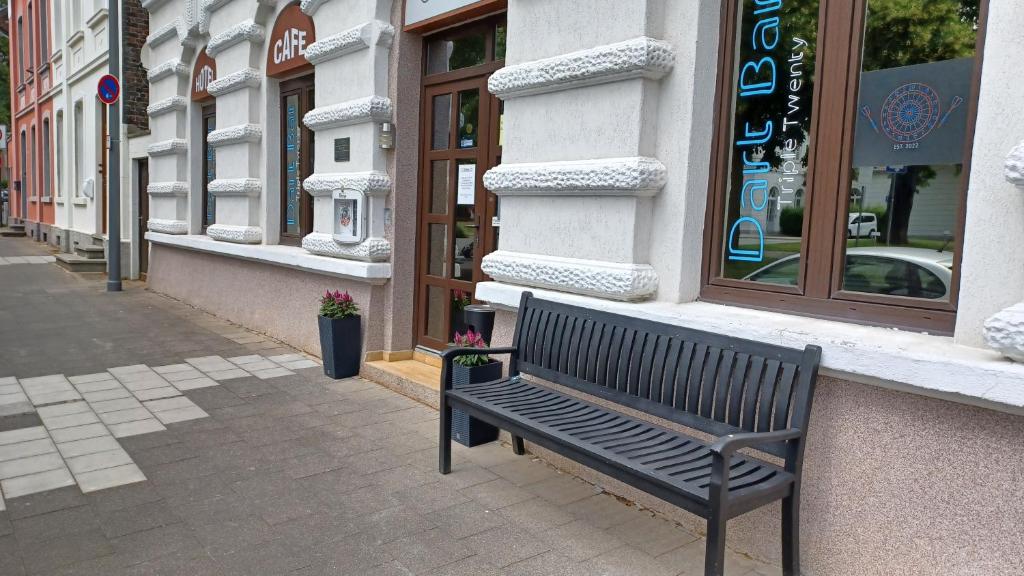 un banc assis devant un bâtiment dans l'établissement Triple Twenty, à Eschweiler