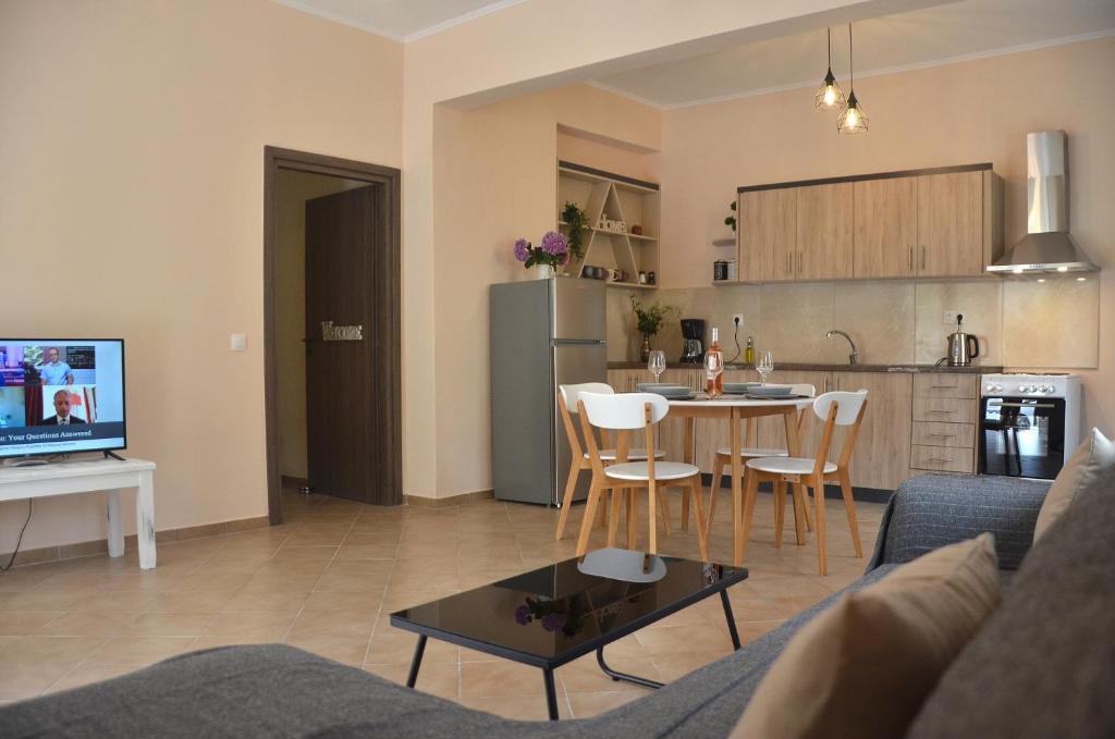 uma sala de estar com um sofá, uma mesa e uma cozinha em Agatha's spacious modern apt-1 em Perítheia