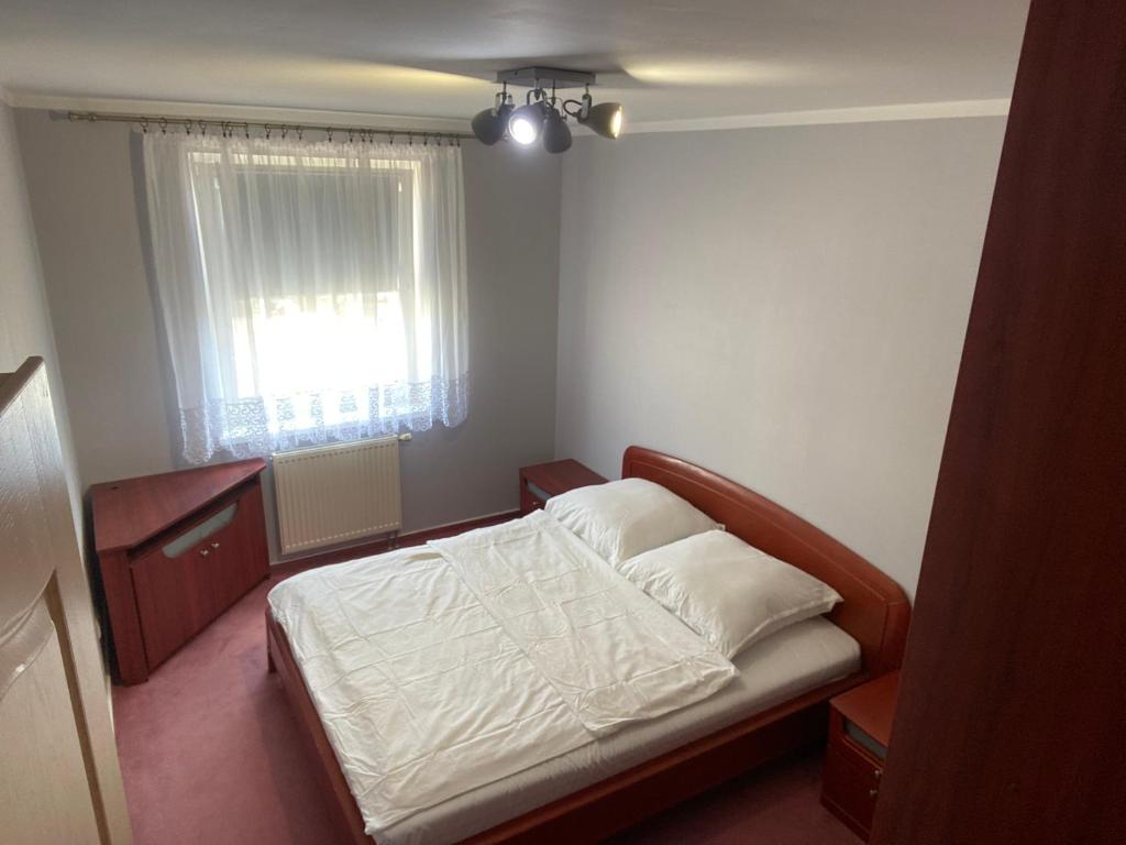 a small bedroom with a bed and a window at Mieszkanie w Giżycku in Giżycko