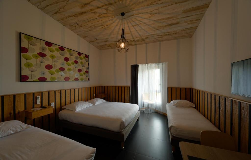 um quarto de hotel com duas camas e uma janela em Cit'Hotel Le Relais du Boisniard em Chambretaud