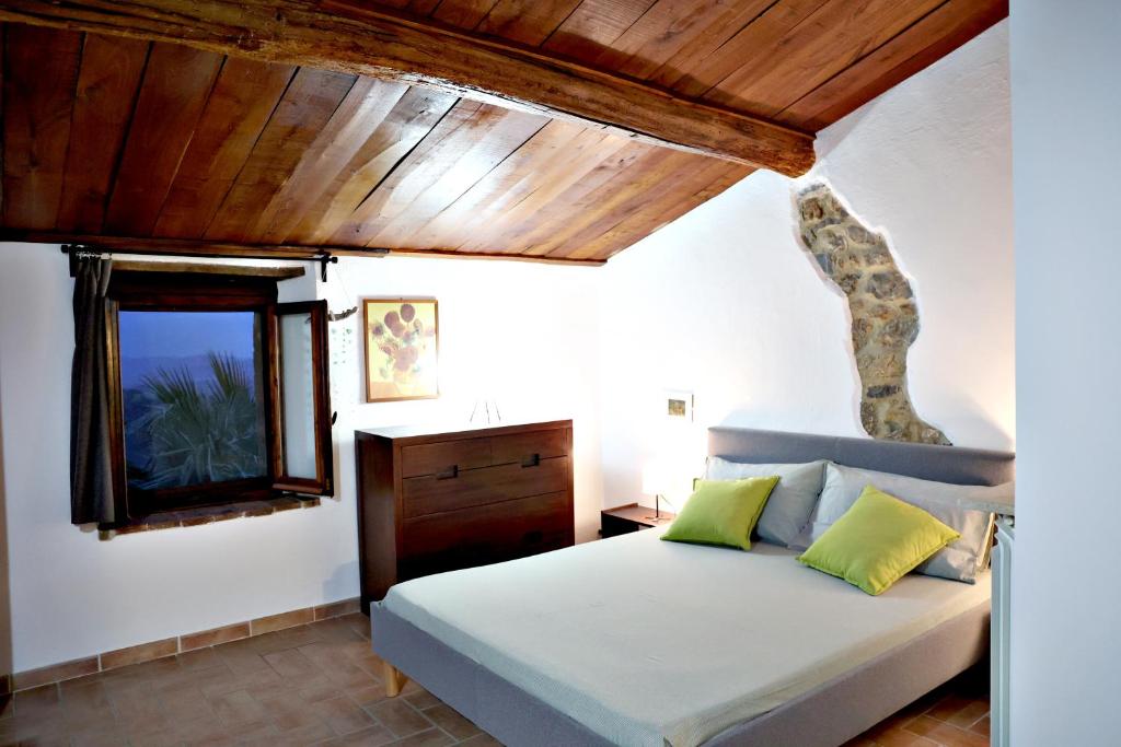 1 dormitorio con cama y techo de madera en Casa MarJù en Montemassi