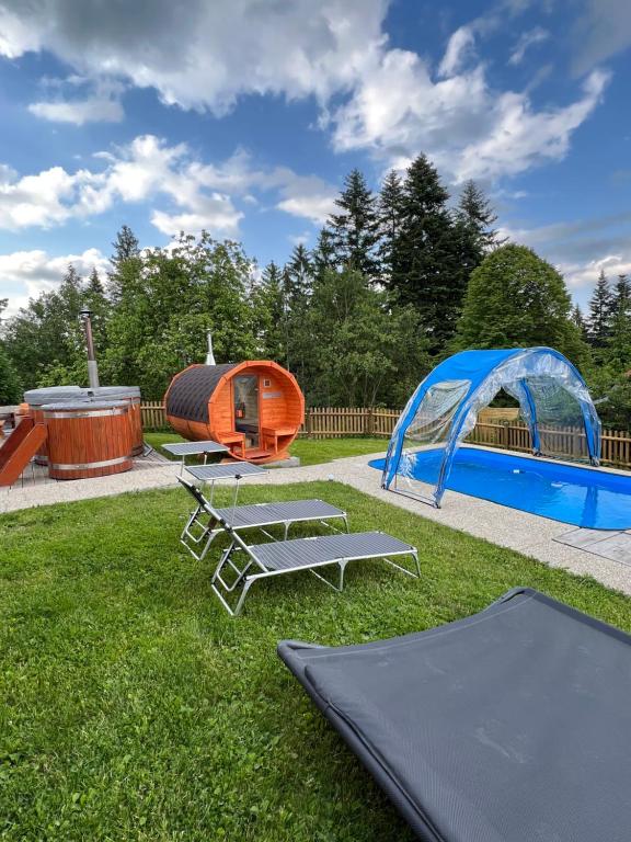 a backyard with a gazebo and two trampets and a tent at Wellness chata Kozička in Klokočov