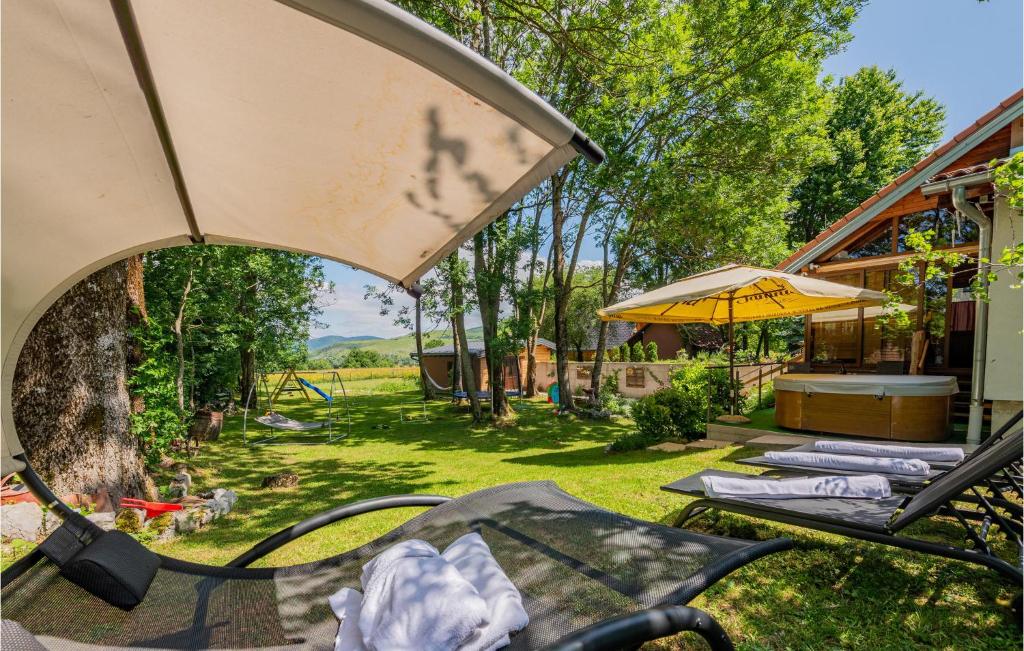 a patio with a table and an umbrella at Pet Friendly Home In Mazin With Sauna in Mazin