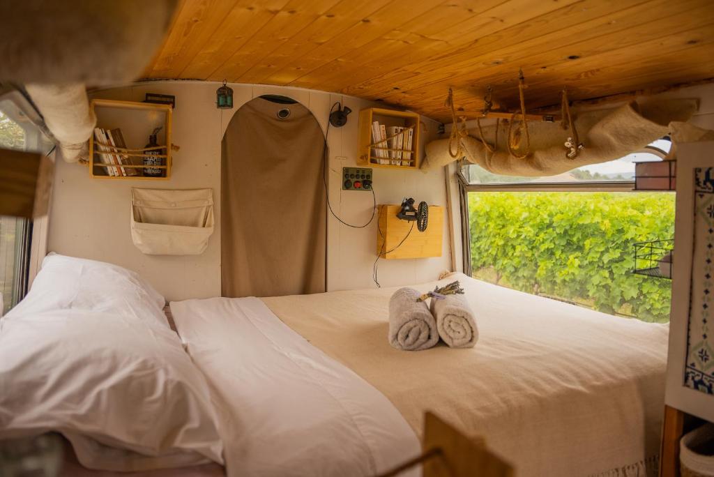 een slaapkamer met een bed met handdoeken erop bij Nuit insolite au milieu des vignes in Goult