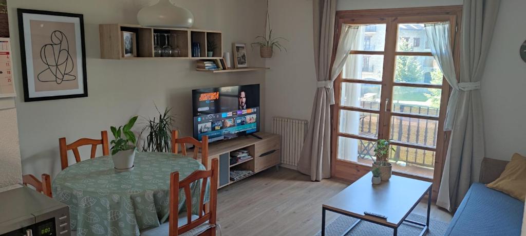 貝納斯克的住宿－Apartamento en Benasque，客厅配有桌子和电视