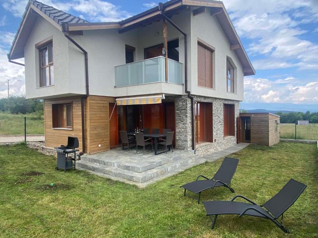 una casa con mesa y sillas en el patio en Villa Serge in Pirin Hills en Razlog