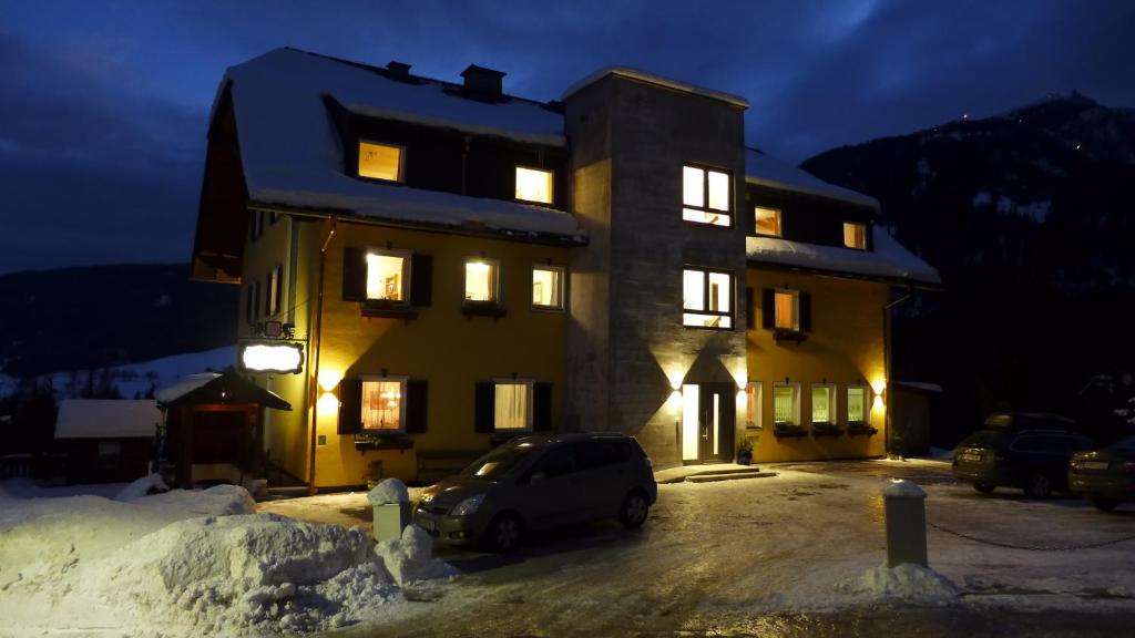 ein Auto, das nachts vor einem Gebäude parkt in der Unterkunft Haus Salzburgerland in Mauterndorf