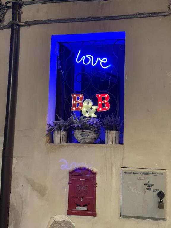 une fenêtre avec un panneau indiquant que nous aimons les bots dans l'établissement B&B Amores, à Sulmona
