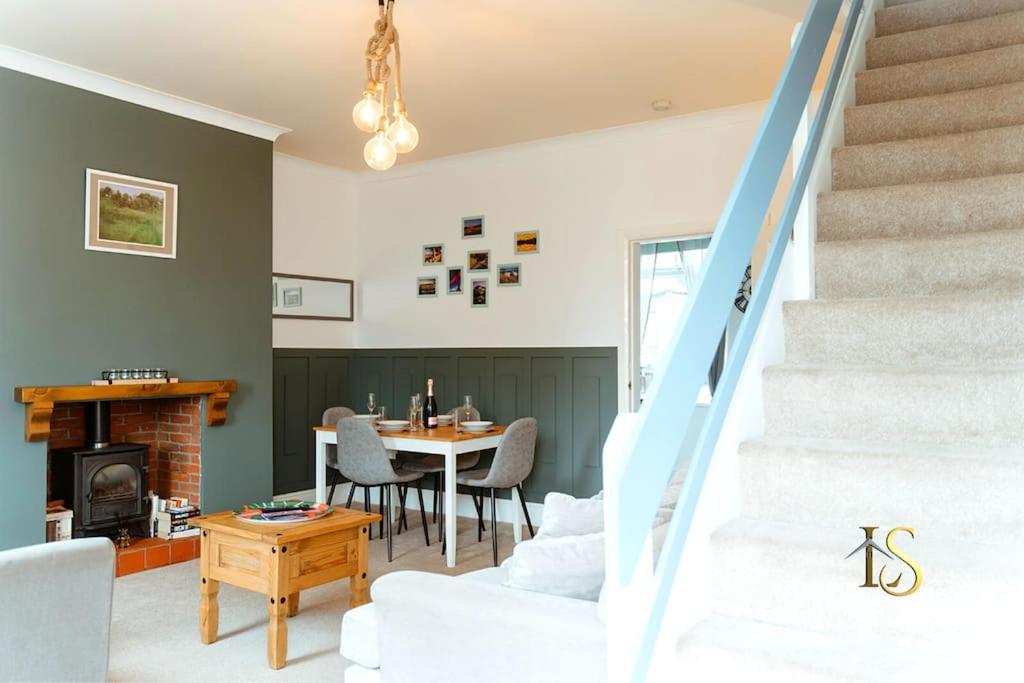 een woonkamer met een trap en een tafel en stoelen bij *Luke Stays Oswald Terrace* in Stanley