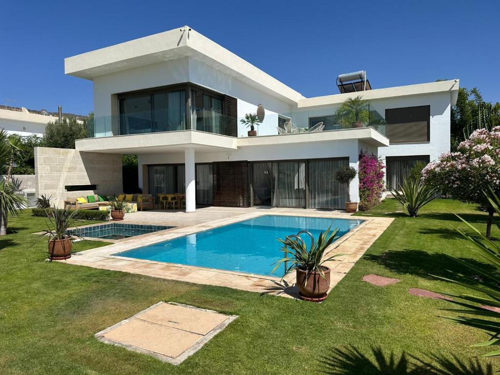 een groot wit huis met een zwembad bij Luxueuze villa Taghazout Bay in Taghazout