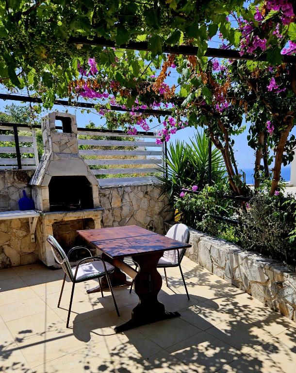 a table and two chairs and a stone oven at Small House Postup in Orebić