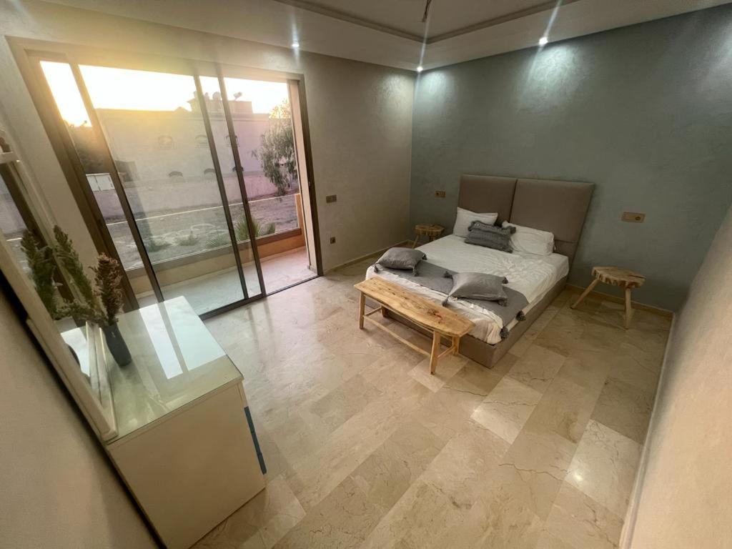 - une chambre avec un lit et une grande fenêtre dans l'établissement Villa contemporaine, à Marrakech
