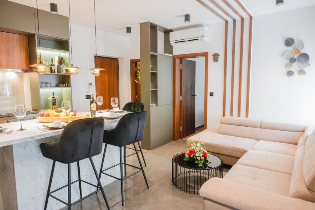 a kitchen and living room with a couch and a table at Drnis Bliss apartment in Drniš