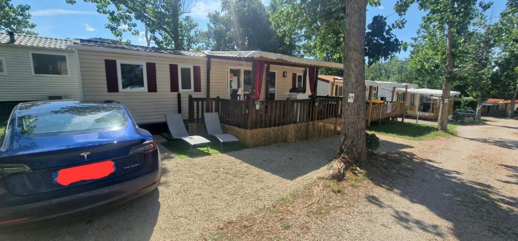 une maison avec une voiture garée devant elle dans l'établissement Mobil-home de vacances, à Le Bosc