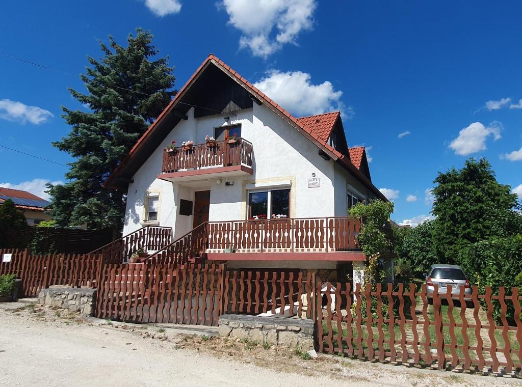 a house with a wooden fence in front of it at Baker Street Apartman in Balatonalmádi