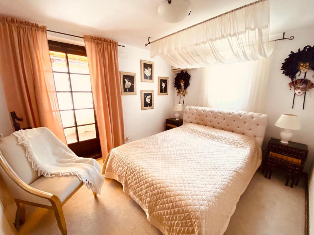 a bedroom with a bed and a chair and a window at Villa Golda in Petrovac na Moru