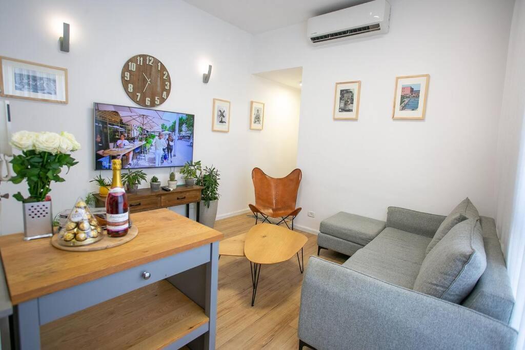 a living room with a couch and a clock on the wall at Amazing Dizengoff Square Home in Tel Aviv