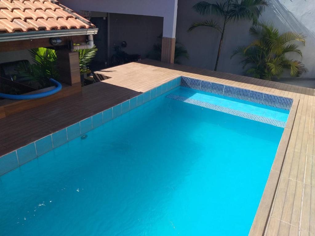 una gran piscina azul con una casa en Cantinho do Rafa en São Lourenço