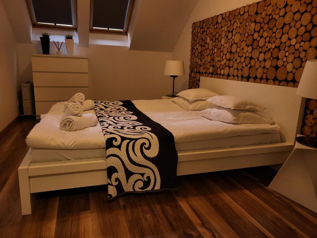 a bedroom with a bed with a black and white blanket at Kamienica Nadmorska in Jastarnia