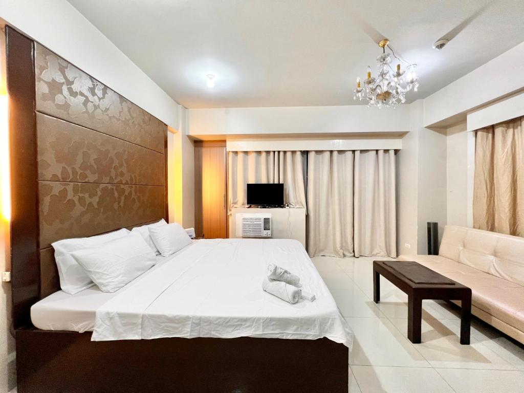 a bedroom with a large bed and a couch at Kiel 5-Star Condo Hotel Across NAIA Manila Airport Terminal 3 in Manila