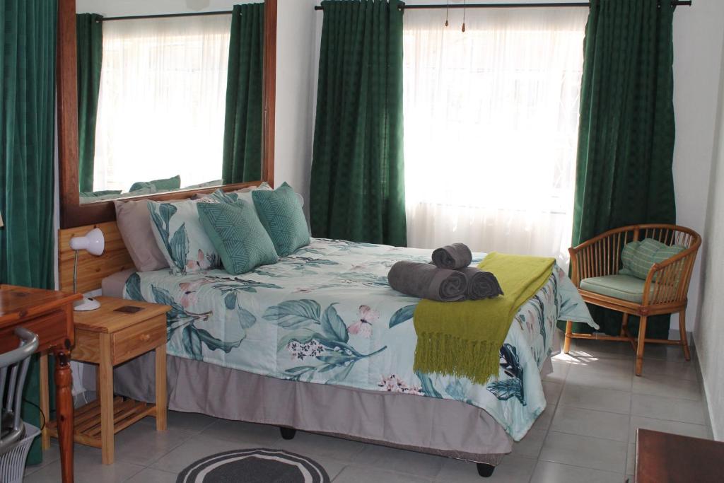 - une chambre avec un lit et des rideaux verts dans l'établissement Bush Lilly Cottage, à Hazyview