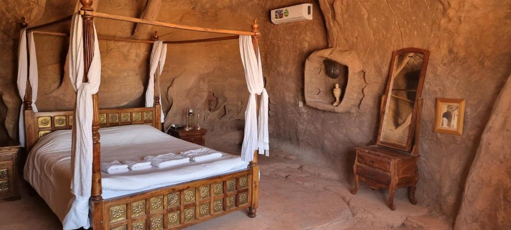 1 dormitorio con cama con dosel y mesa en Obeid's Bedouin Life Camp, en Wadi Rum