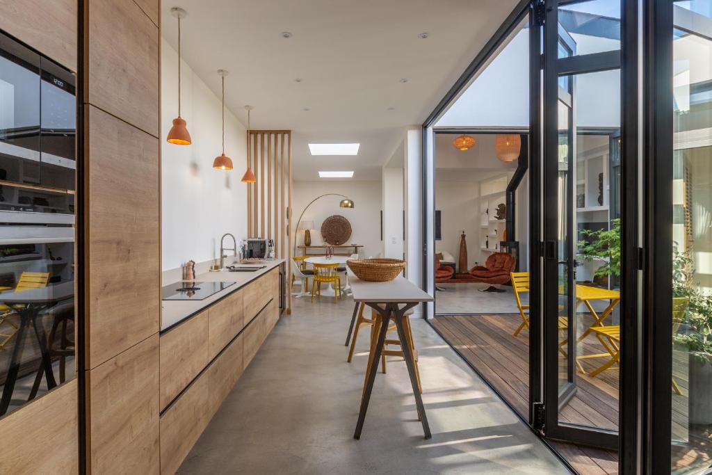 a kitchen and dining room with a view of the dining room at Maison-Loft de standing autour de son patio in Vannes