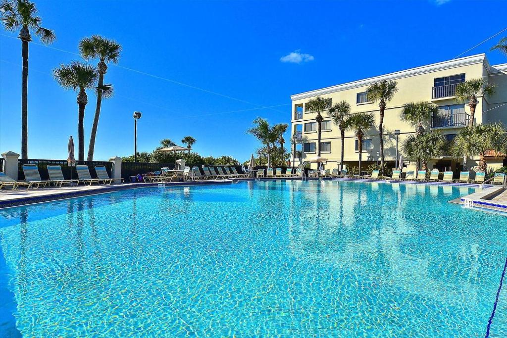 a large blue swimming pool in front of a building at Land's End 10-201 Beach Front - Premier in St Pete Beach