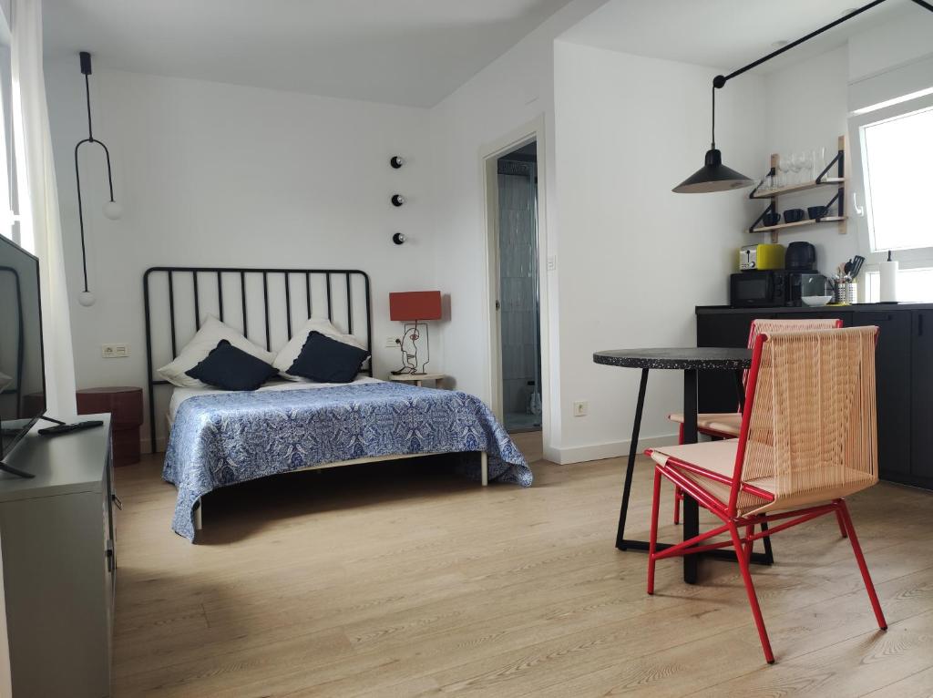 a bedroom with a bed and a table and a chair at Bonito estudio con garaje in Bilbao