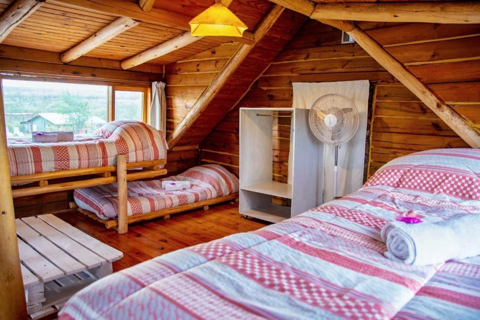 1 dormitorio con 2 camas en una cabaña de madera en Piedramora en Villa Giardino