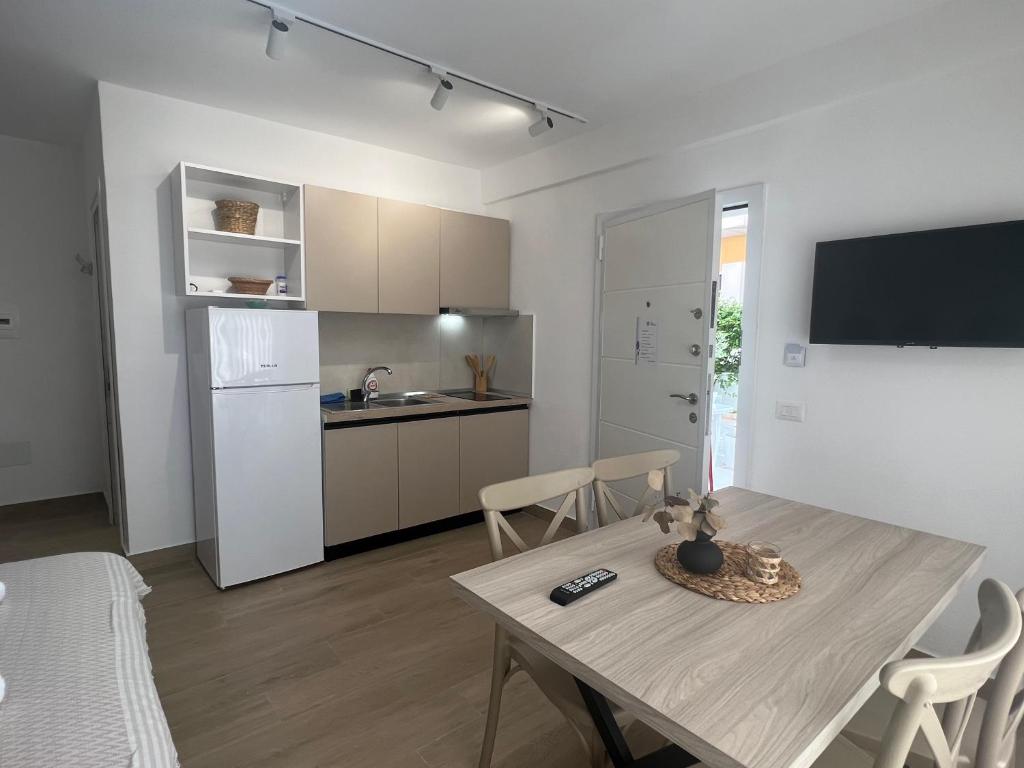 a kitchen and dining room with a table and a refrigerator at Art Studio Apartments Durrës in Durrës