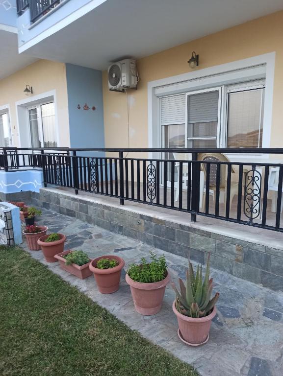 una fila di piante in vaso davanti a una casa di Irini apartment 3 a Néa Koútali
