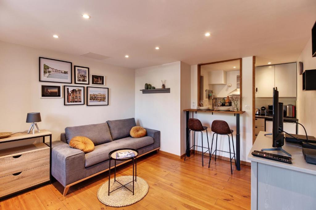 uma sala de estar com um sofá e uma cozinha em Appartement cosy, confortable et idéalement situé em Lyon